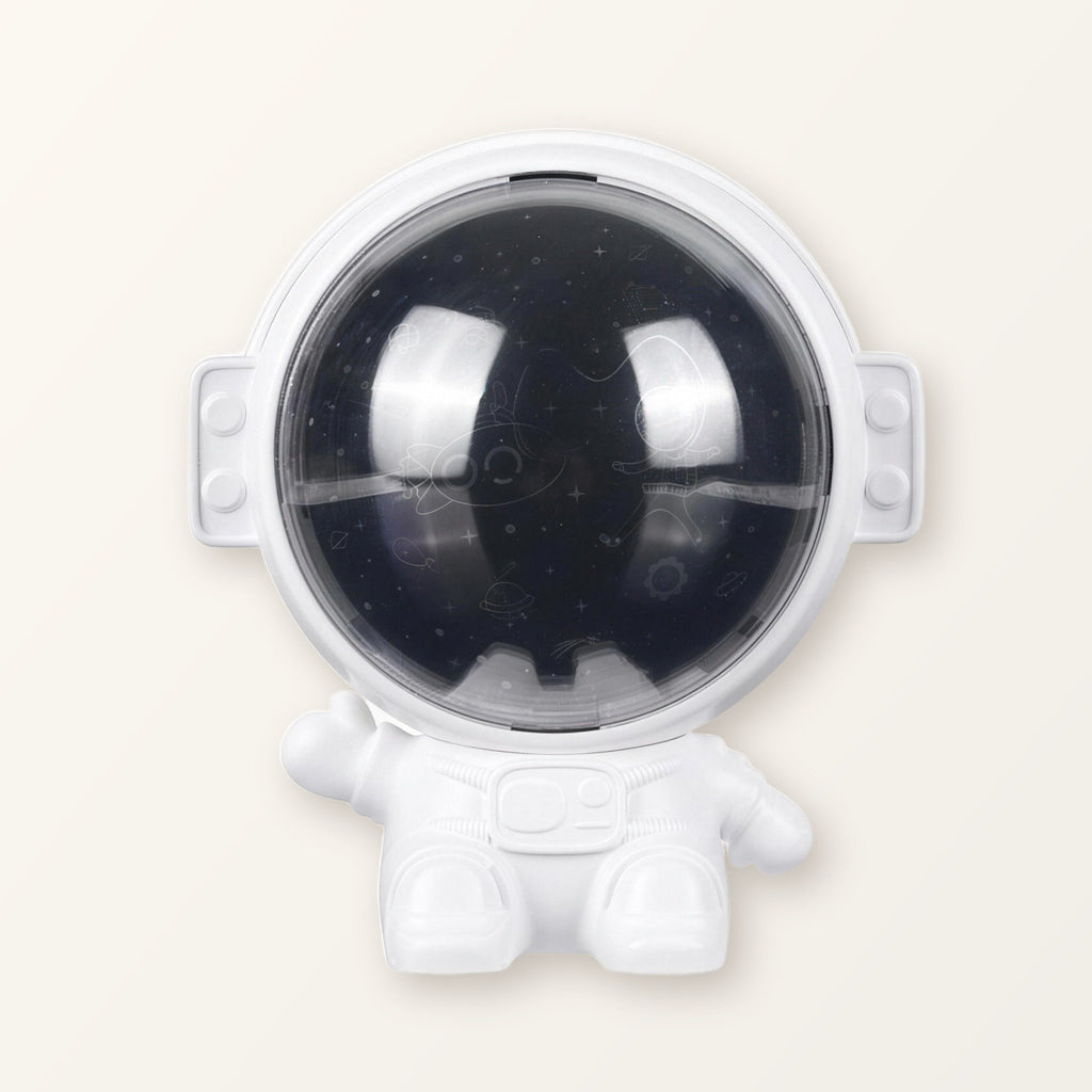 White astronaut star projector with a dark space-print visor on a plain cream background
