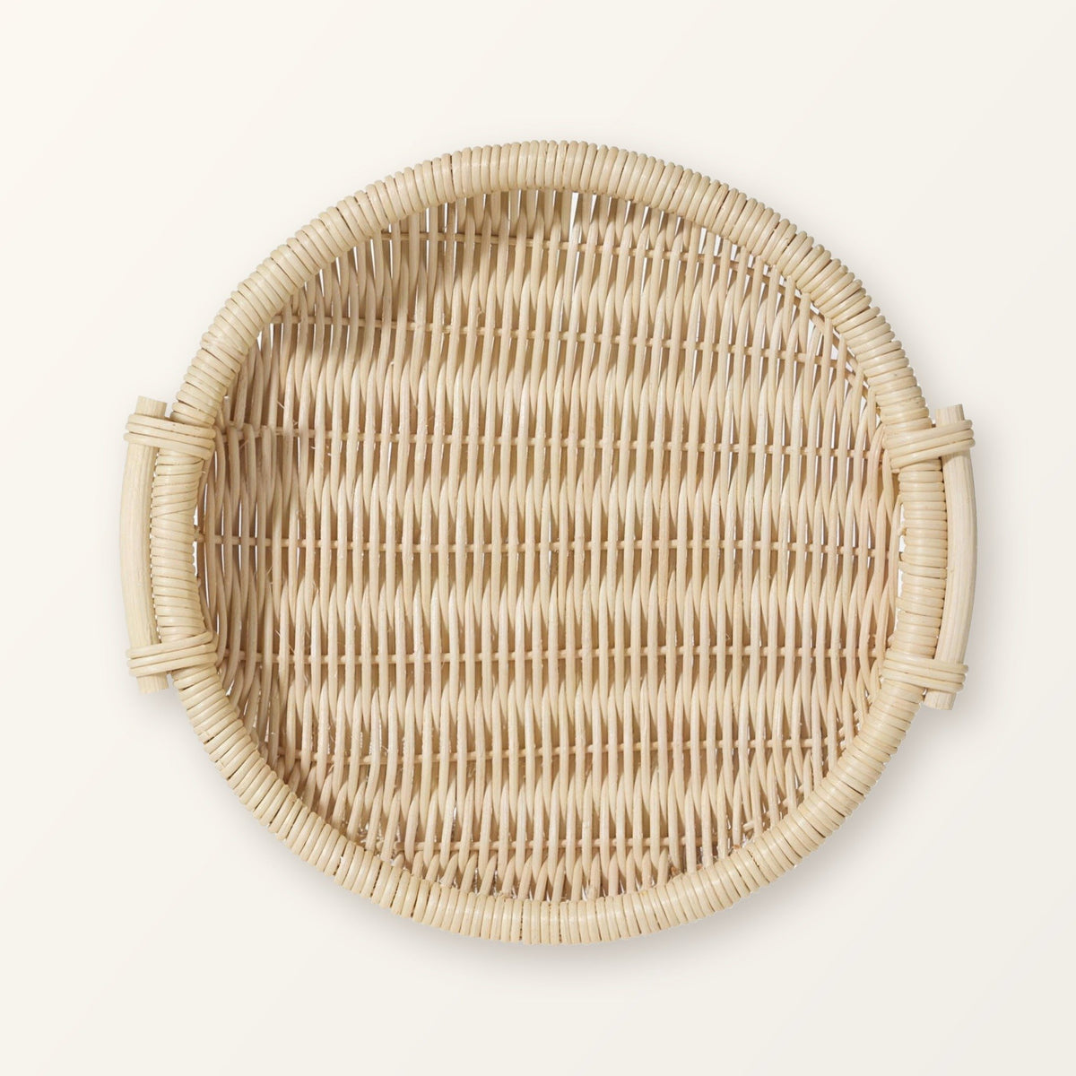 Round woven rattan tray with two side handles in pale natural rattan, seen from above