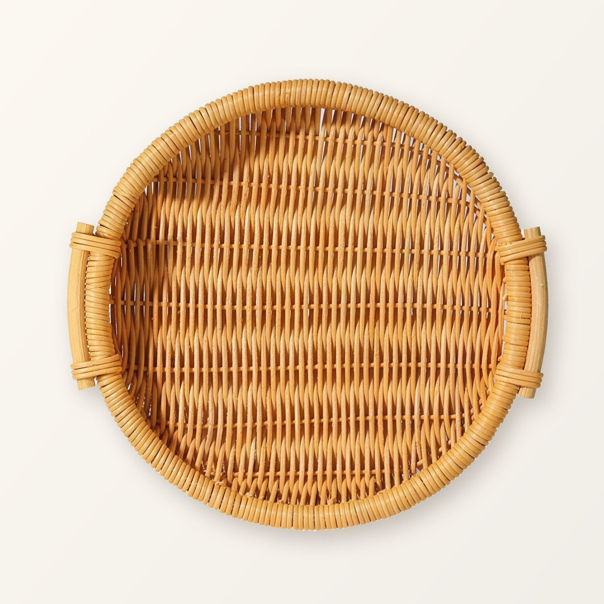 Round woven rattan tray with two side handles in honey rattan, seen from above