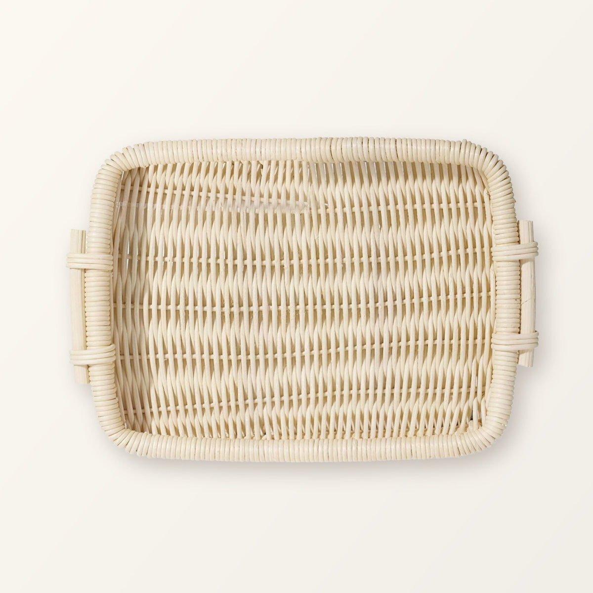 Rectangular woven rattan tray with two side handles in pale natural rattan, seen from above