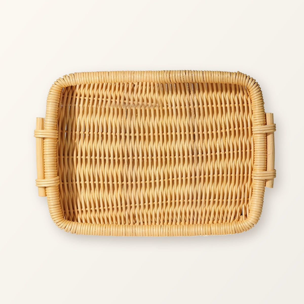 Rectangular woven rattan tray with two side handles in honey rattan, seen from above
