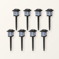 Eight black pagoda-style solar path lanterns on ground stakes, in two rows on a plain cream background