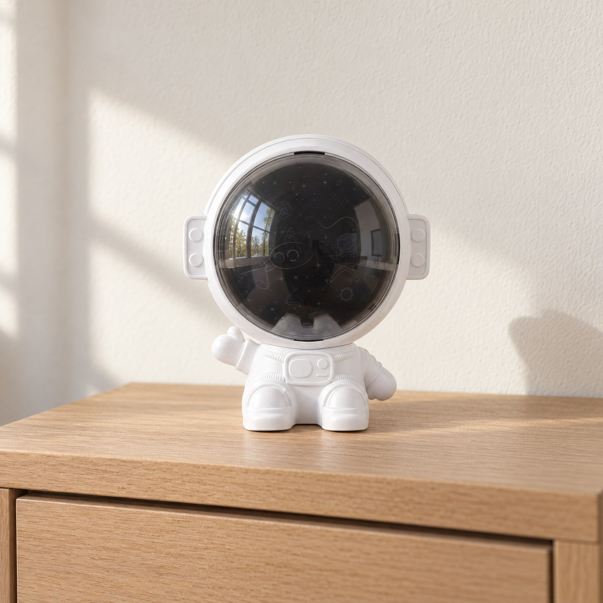 White astronaut star projector switched off on an oak nightstand in daylight