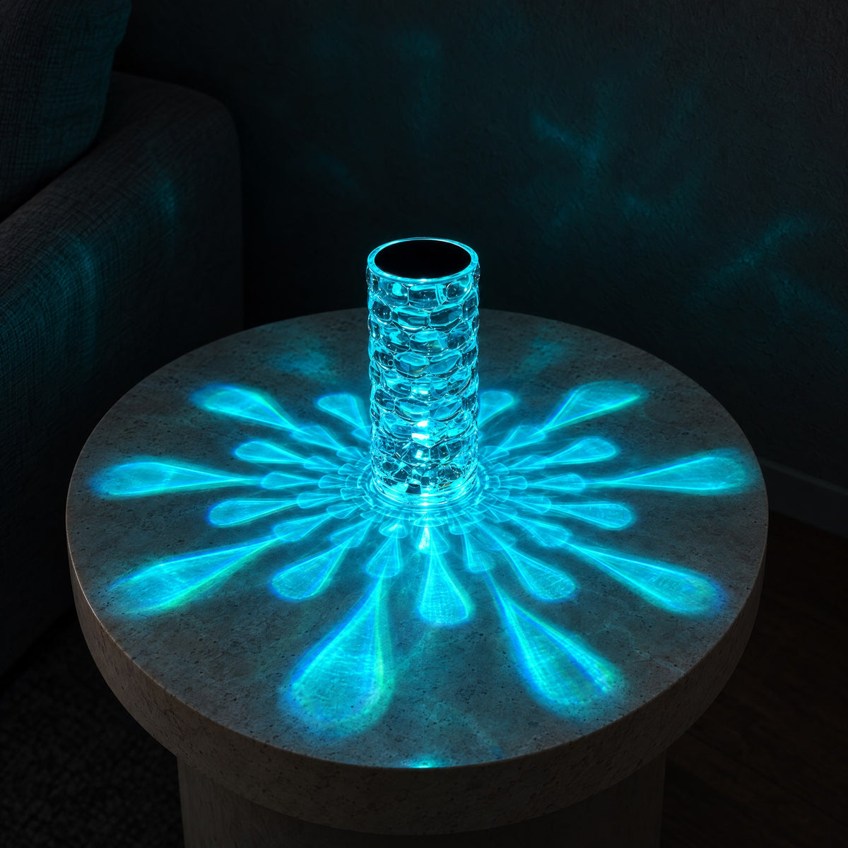 16-colour style of the crystal-look acrylic lamp glowing cyan, with a cyan starburst across a round stone side table