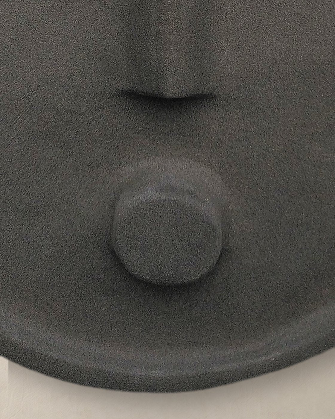 Close-up of the round chin and textured matte anthracite glaze of the ceramic mask