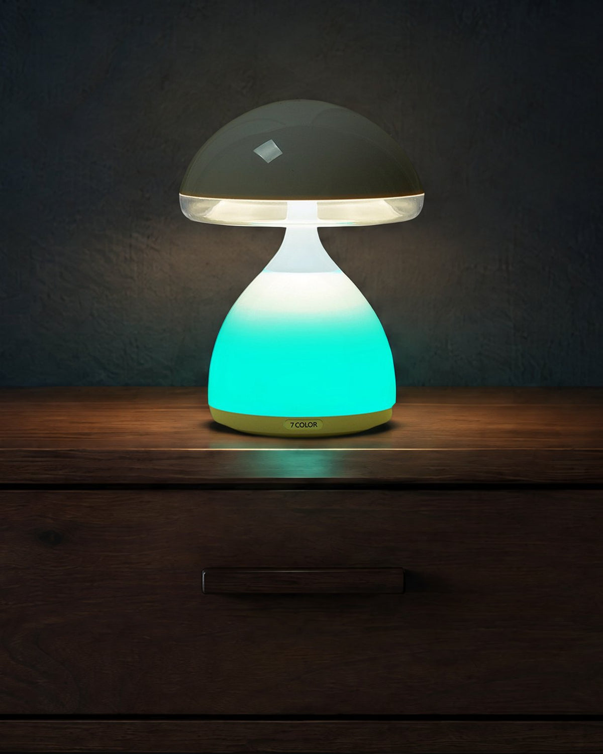 Close view of the lit mushroom lamp on a dark walnut nightstand, teal base and white light under the cap