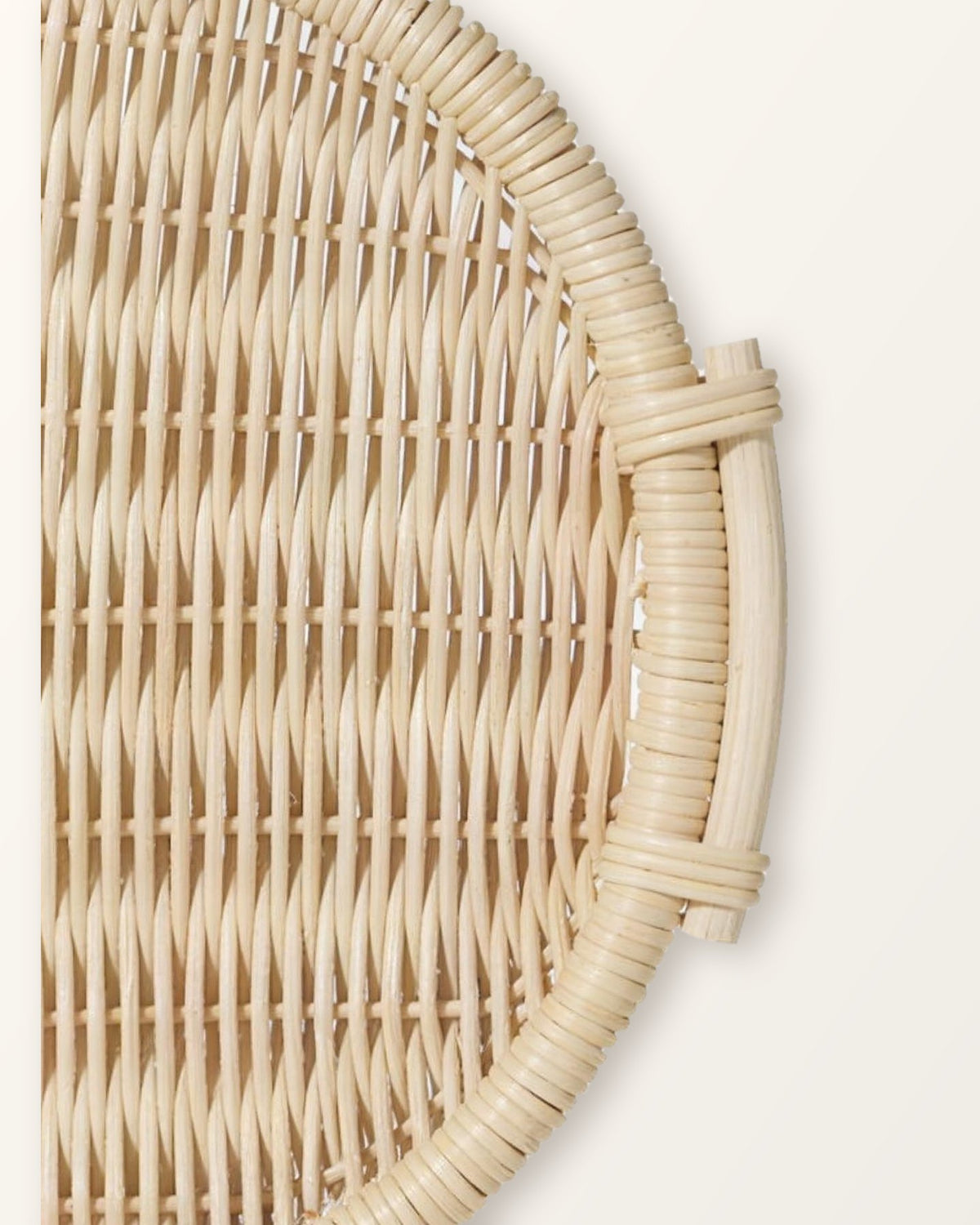 Close-up of a side handle bound to the rim of the round natural rattan tray