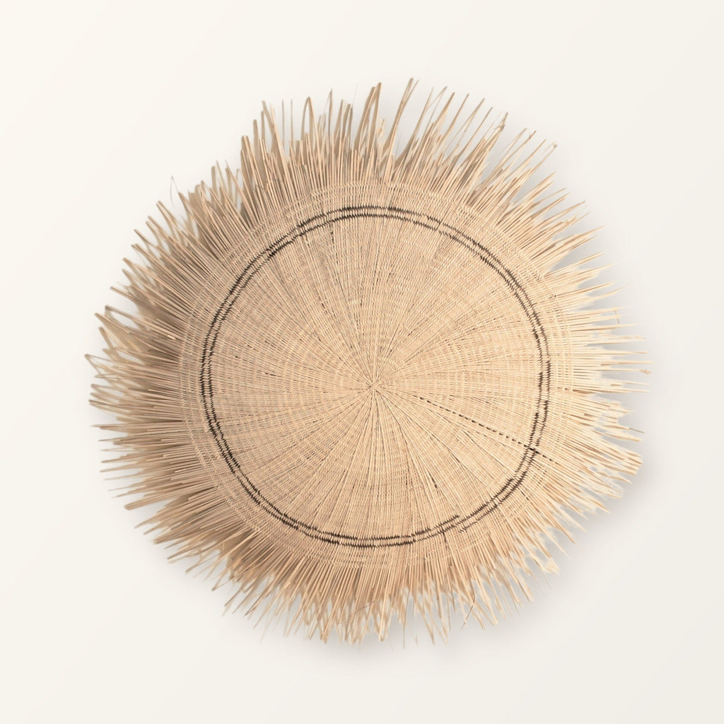 Sun Circle woven wall piece in natural straw with a brown stripe and a fringed edge, 36 in across