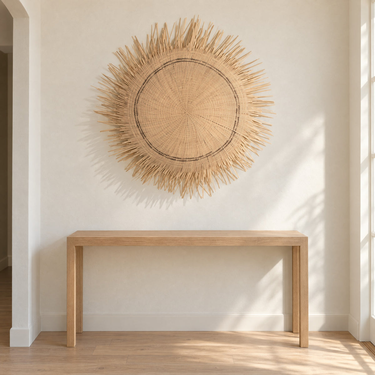 Sun Circle woven wall piece hung on a warm white wall above a slim oak console table