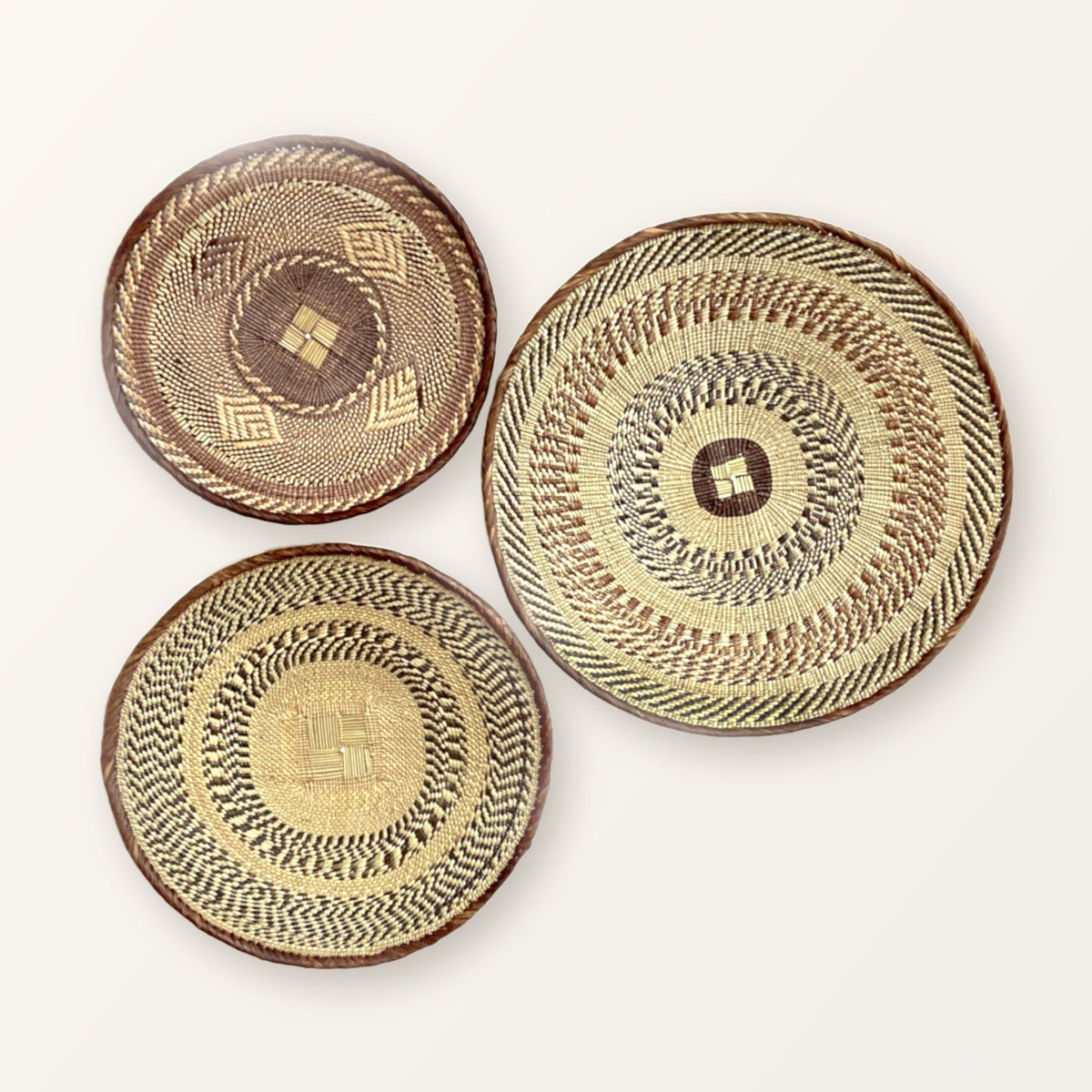 Three handwoven Tonga wall baskets in natural and brown tones, patterns vary