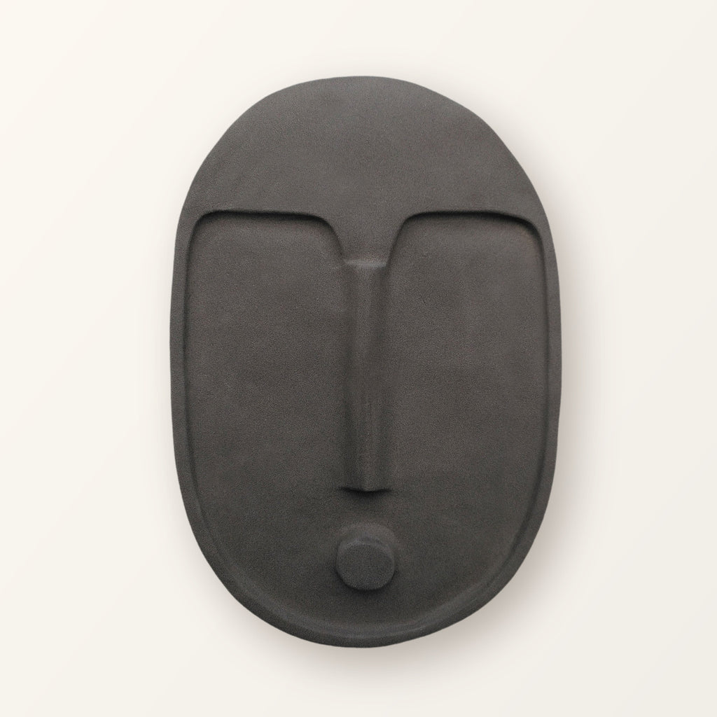 Ceramic wall mask in textured matte anthracite grey: an abstract face with a raised brow and nose